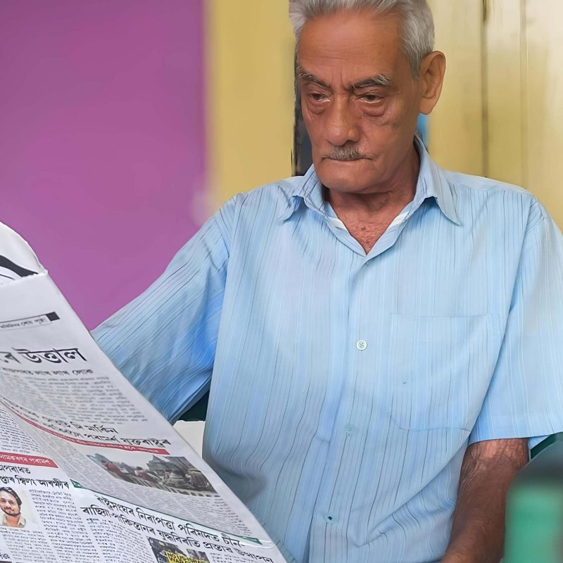 Elderly man reading a newspaper after experiencing improved eye health through natural supplements